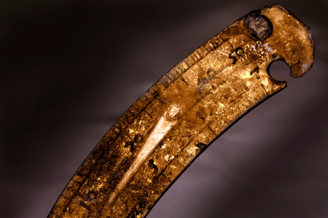 A close up of the scale on a copper alloy navigational instrument that was partially buried in the silt. The silted, anaerobic environment of the Thames Estuary is perfect for preserving such fine detail. (c) Luke Mair